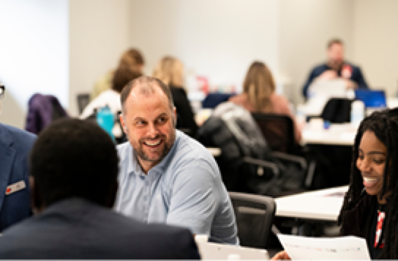 Group of participants reviewing papers in classroom-style setting.