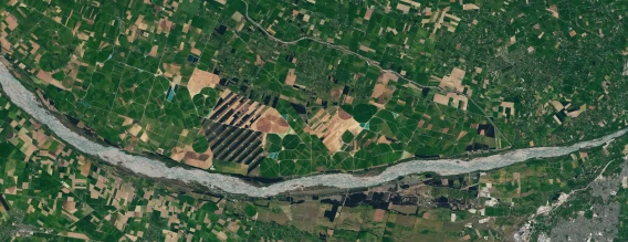 Satellite view of farmland divided into fields with a river running through the landscape.