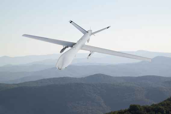 Spy unmanned aerial vehicle (UAV) flies over low mountains in mist